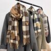 Women's plaid fringe scarves in black and white, camel, and pink color options