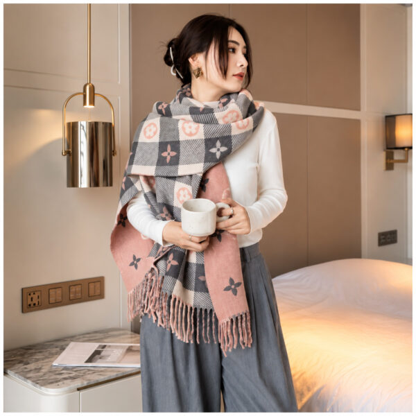 Woman wearing a black and white plaid fringe scarf with camel accents